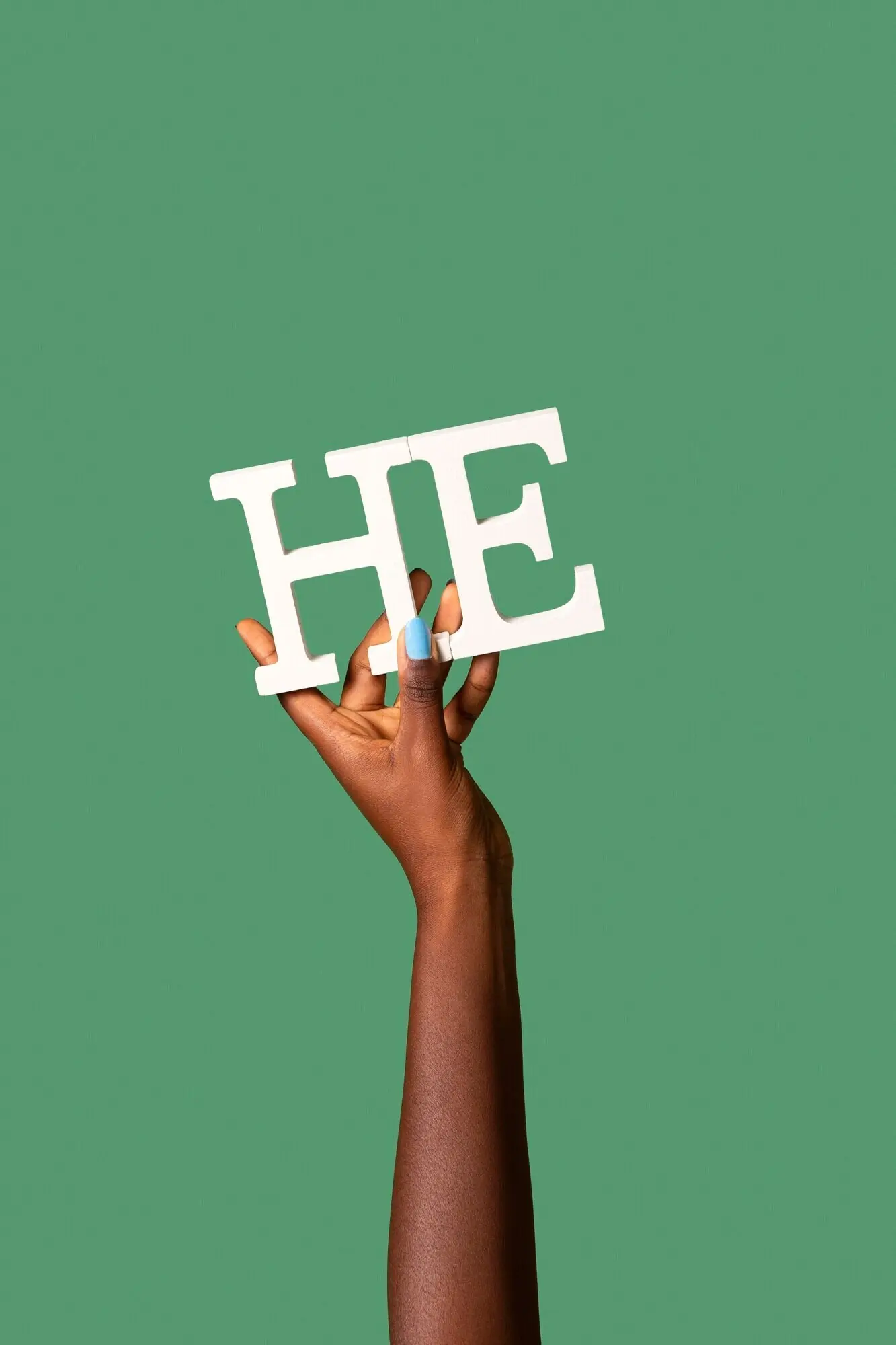 Гендерфлюидный человек, держащий бумажное местоимение.