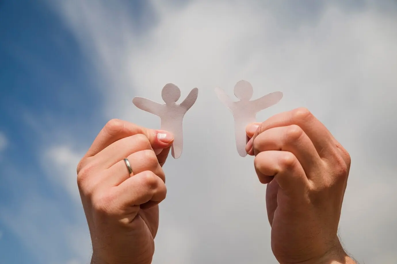 Бумажные человечки на фоне неба.